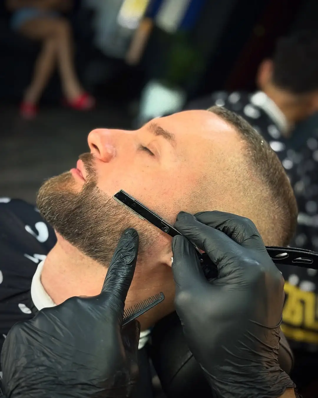 Barbero perfilando barba con navaja